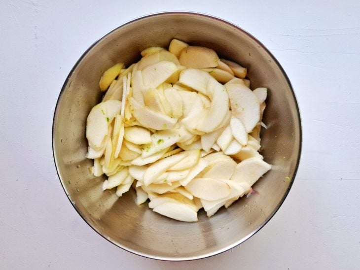 Uma bacia com maçã, raspas e suco de limão.