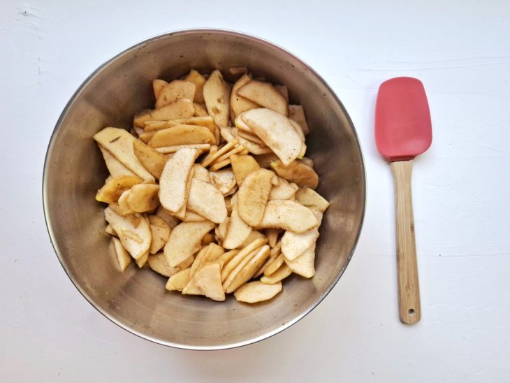 Uma bacia com maçã fatiada e temperos.