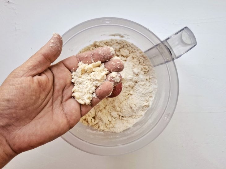 Um processador contendo farinha, açúcar refinado, sal e manteiga.