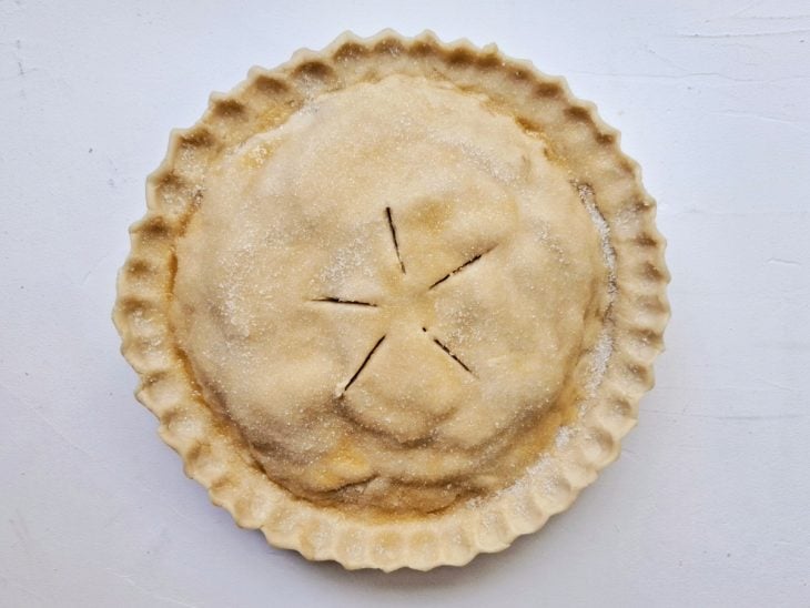 Uma forma com a torta de maçã finalizada para assar.
