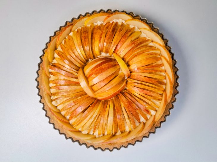 Fatias de maçã organizadas de forma decorativa sobre o creme.