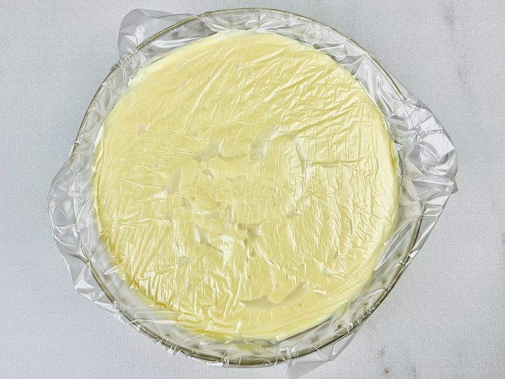 Creme transferido para uma tigela coberta com plástico.