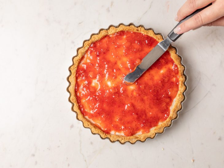 Torta coberta por geleia de morango.
