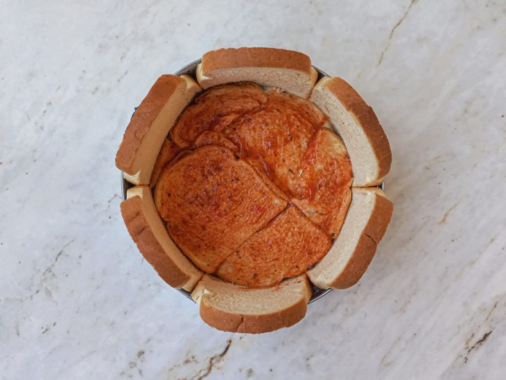 Molho de tomate espalhado ao fundo da forma.