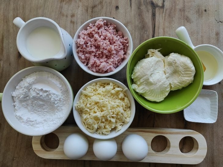 Ingredientes para preparar a receita de pão de queijo fácil separados em uma bancada.