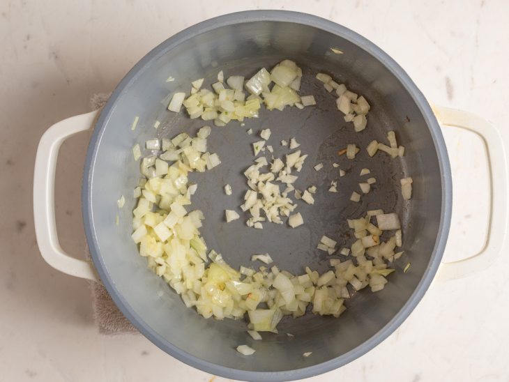 Alho e cebola refogados numa panela.