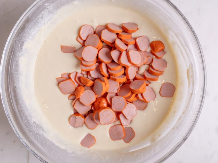 adição da salsicha a massa de torta de liquidificador.