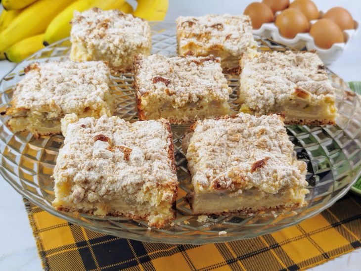 Fatias de torta farofa de banana pronta para consumo sobre um prato de vidro.