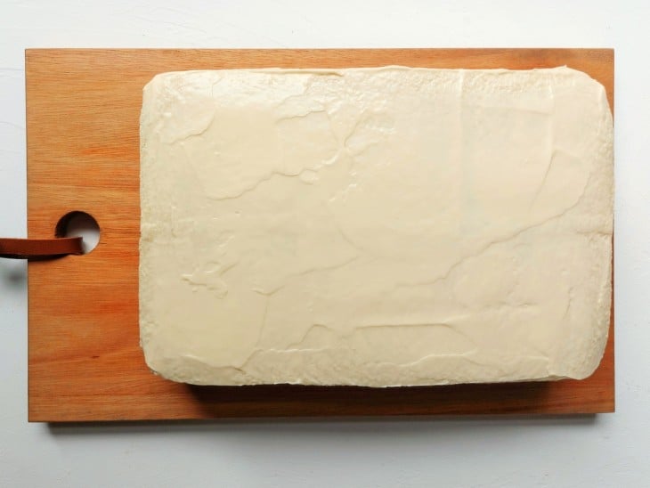 Uma torta de pão desenformada coberta com maionese.