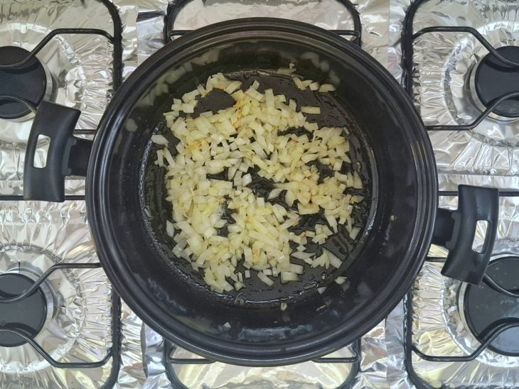 Panela com cebola e alho refogando.