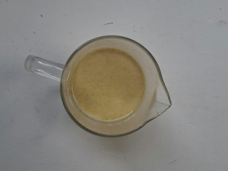 Recipiente com a mistura de farinha de trigo, leite em pó, creme de cebola e a água.