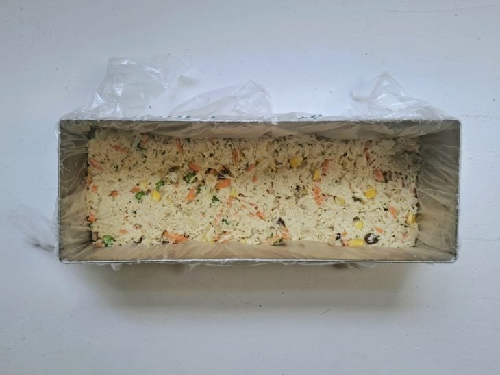 Forma com uma camada de pães e recheio.