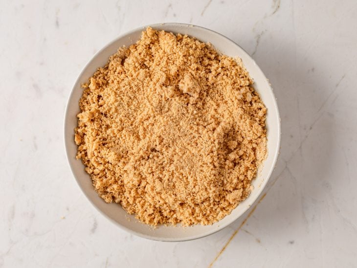 Recipiente com farofinha de biscoito e manteiga.