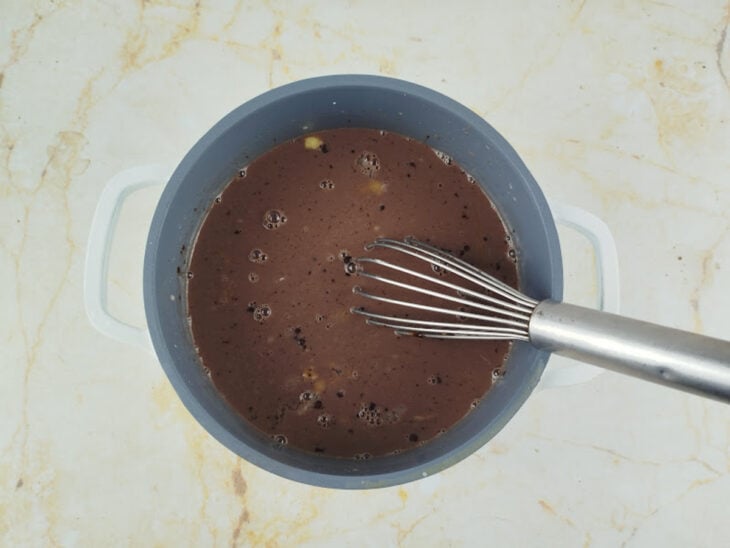 Ingredientes do creme sendo misturados na panela ainda com o fogo desligado.