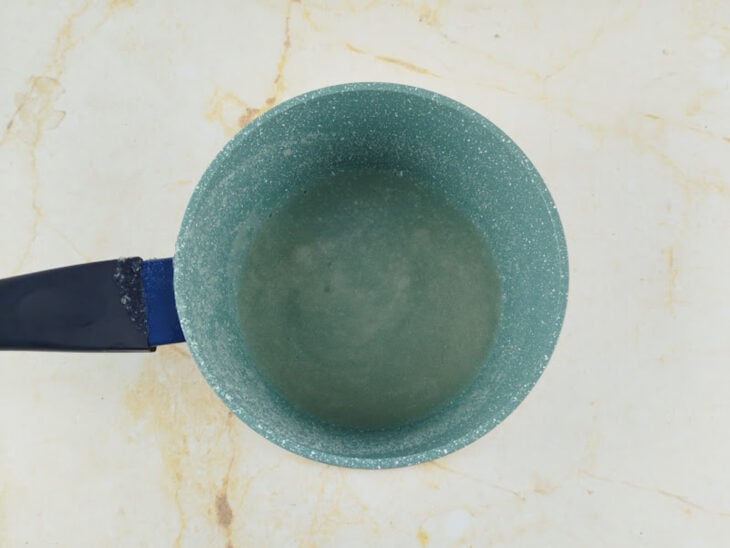Gelatina incolor sendo hidratada com água fria em um recipiente.