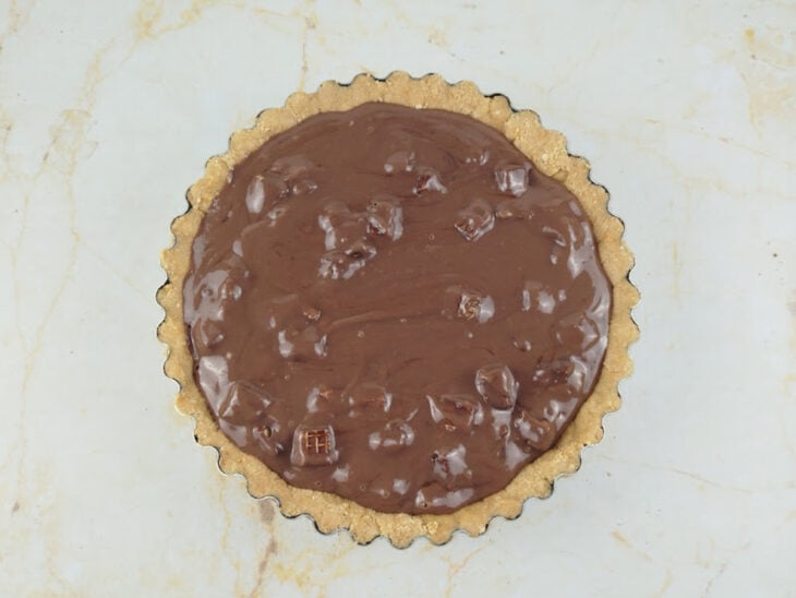 Recheio sendo despejado sobre a base da torta na forma.