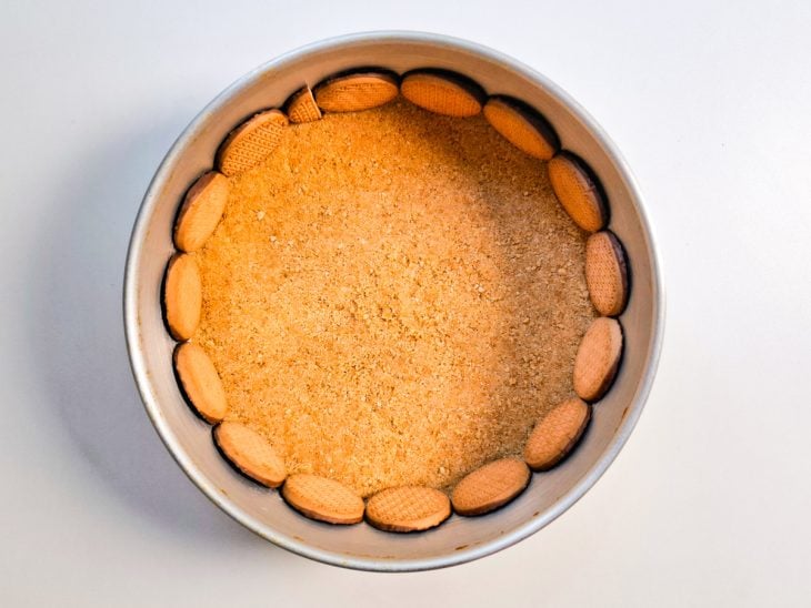 Bolachas com cobertura de chocolate posicionadas na lateral da forma.
