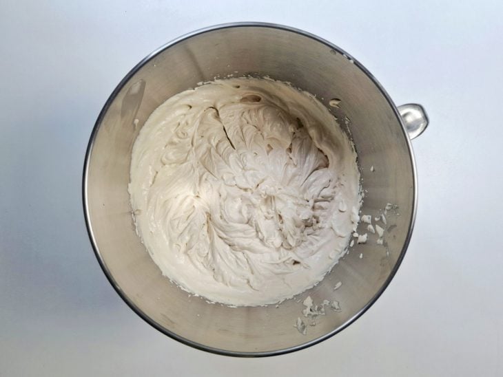 Manteiga, açúcar de confeiteiro, creme de leite e essência de baunilha batidos no recipiente da batedeira.