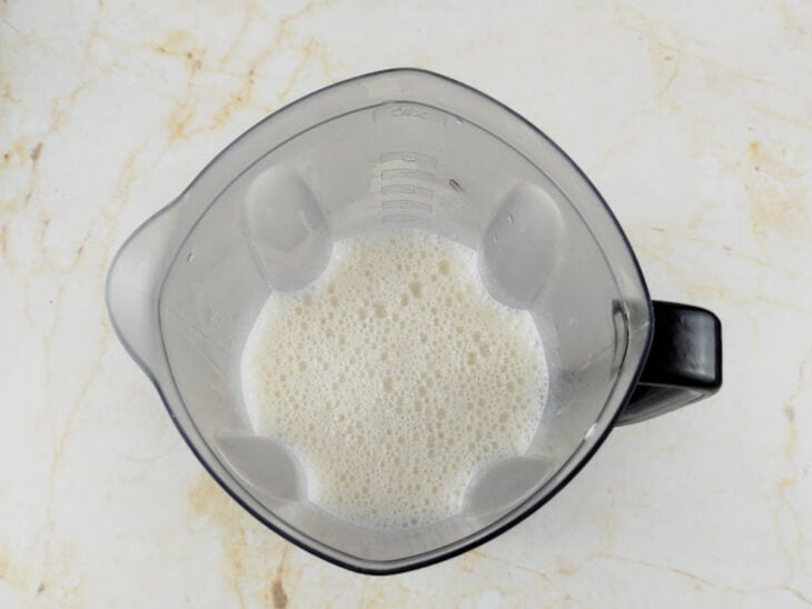 Ovos, óleo, leite e sal sendo batidos no liquidificador.