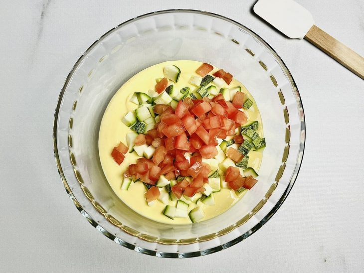 Tomate e abobrinha adicionados a tigela com a massa.
