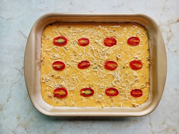 Restante da massa, parmesão e tomates-cereja adicionados sobre o recheio.