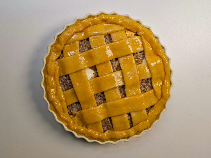 Bordas fechadas e gema pincelada sobre a massa.