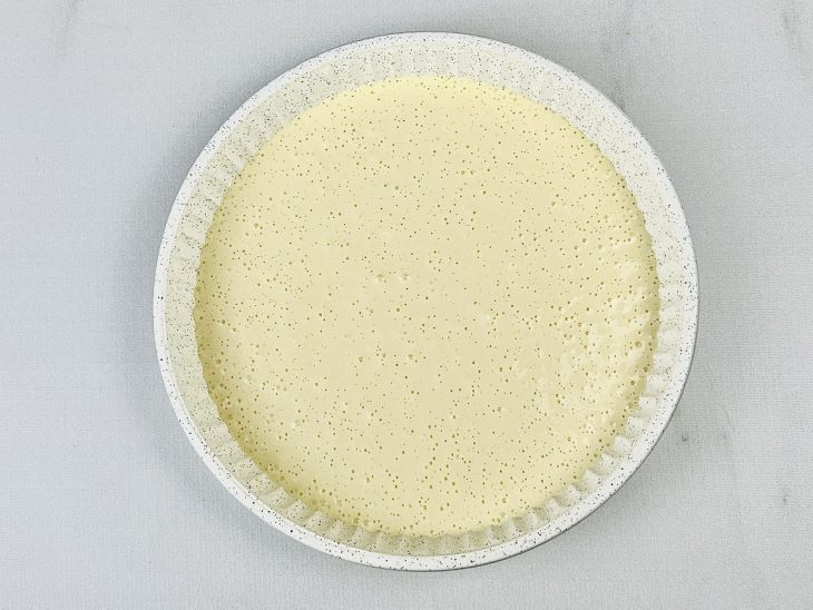 Metade da massa adicionada em uma forma untada.