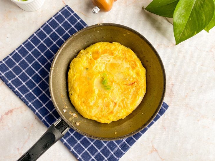 Tortilha de batata fritando na panela.