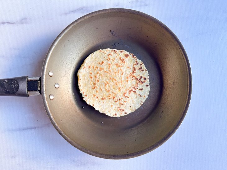 Tortilha de milho frita na frigideira.