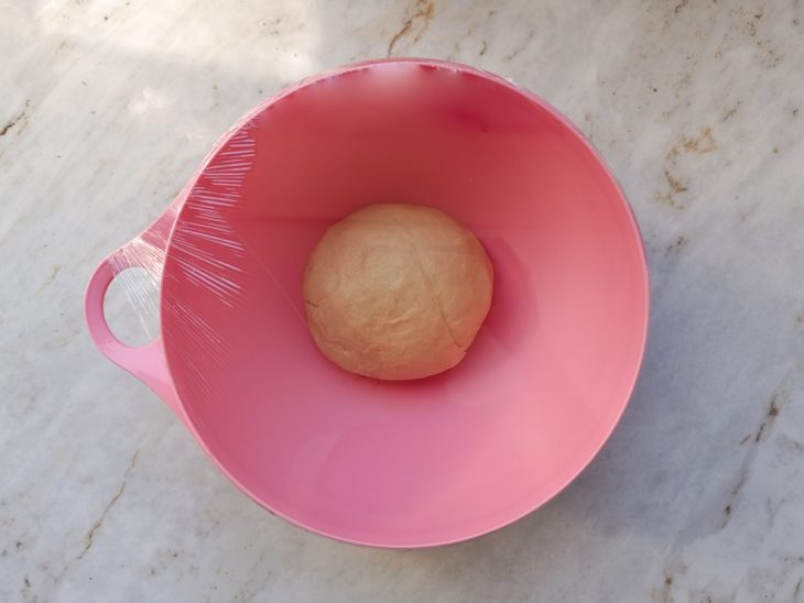 Massa descansando numa tigela coberta.