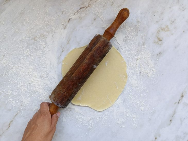Massa sendo aberta na bancada.