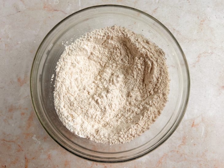 Ingredientes secos sendo misturados em uma tigela grande.