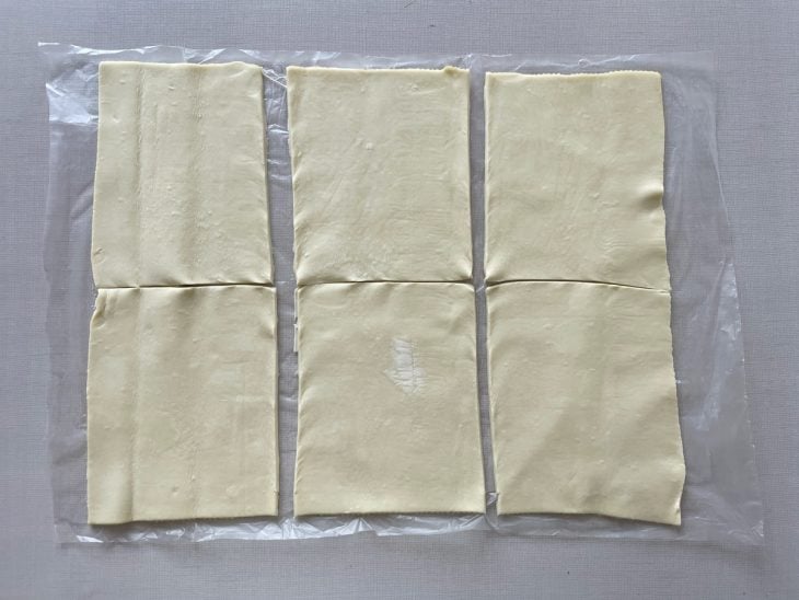 Massa folhada aberta e cortada em retângulos uniformes de 13,5 x 11 cm.