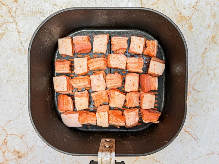 Toucinhos dispostos no cesto da air fryer.
