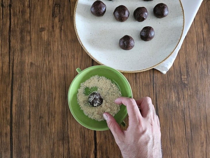 As trufas sendo passadas na farinha de amendoim.