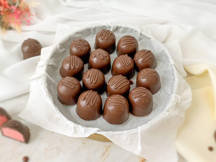 Trufas de morango servidas em um prato redondo.