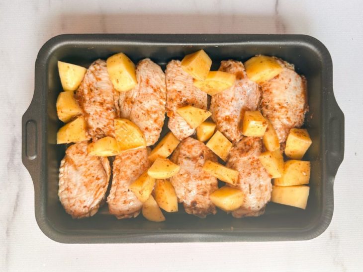 Numa assadeira, as tulipas e as batatas distribuídas.