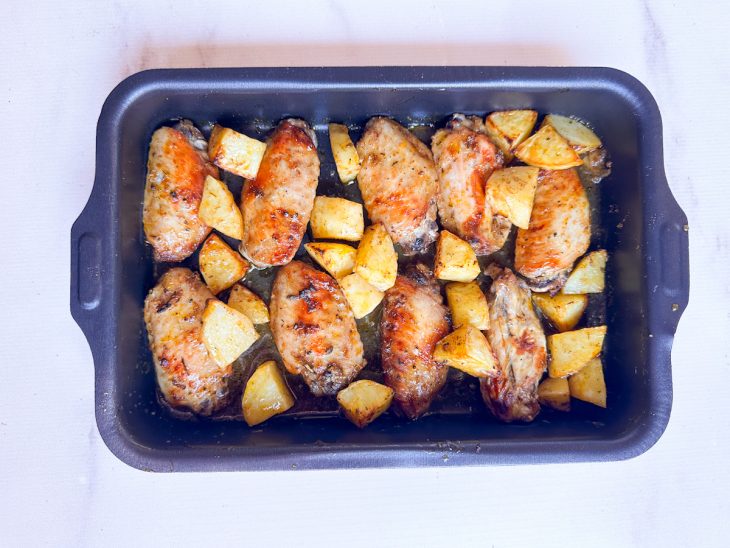 Assadeira retirada do forno na metade do tempo, os ingredientes já começando a dourar.