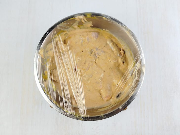 Tulipas mergulhadas na massinha da tigela coberta por plástico-filme.