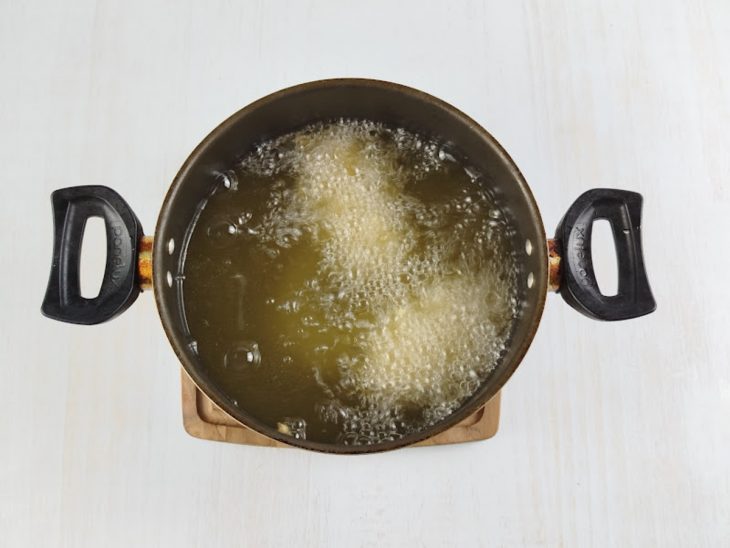 Tulipas fritando em óleo quente numa panela.