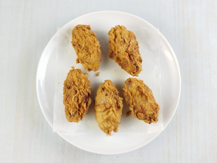 Tulipas fritas colocadas sobre um prato forrado com papel-toalha.