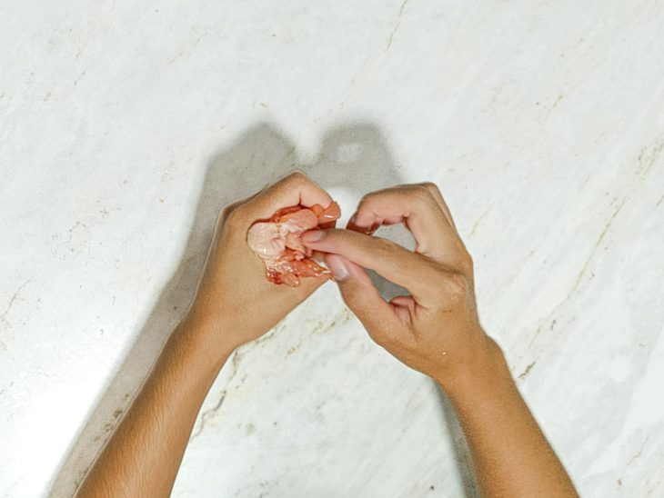 Tulipas sendo recheadas com cubos de queijo e bacon.