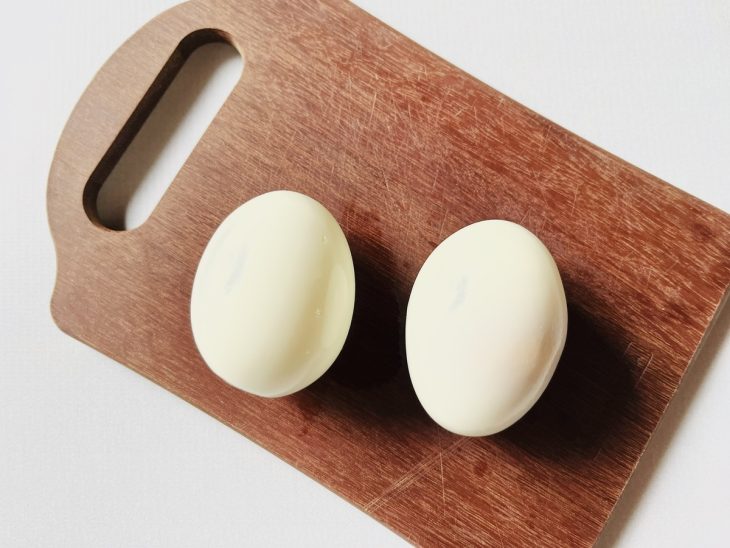 Ovos descascados em uma tábua para serem cortados em 4 partes.