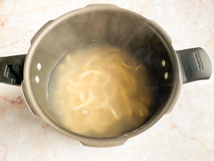 Uma panela com água e o udon a cozinhar.