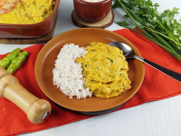 Vatapá pronto, servido em prato acompanhado de arroz branco.