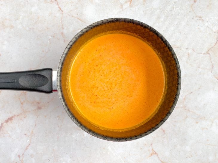 Mistura do liquidificador colocada em uma panela com azeite de dendê adicionado.