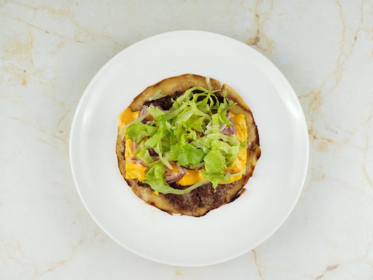 Fora da frigideira, alface e cebola adicionadas ao wrap.