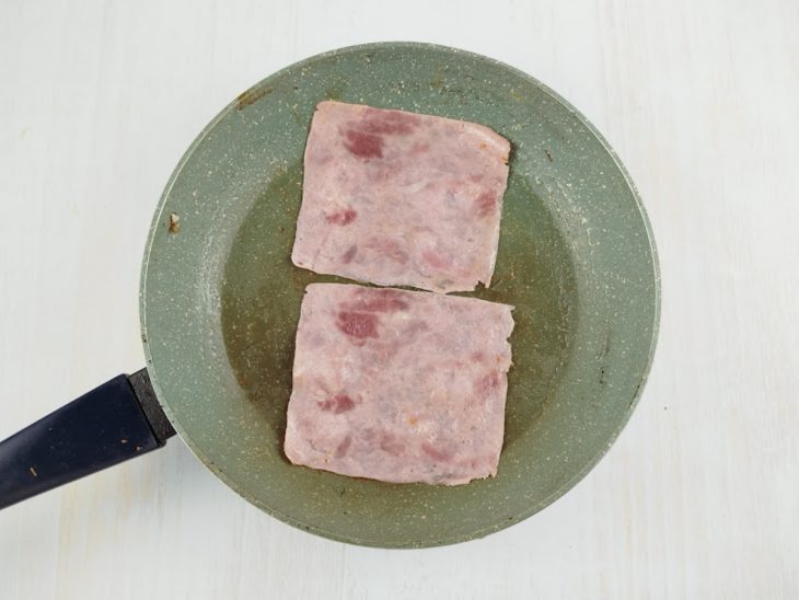 Fatias de presunto numa frigideira.