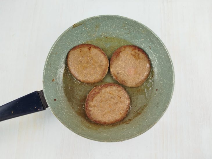 Hambúrgueres numa frigideira.