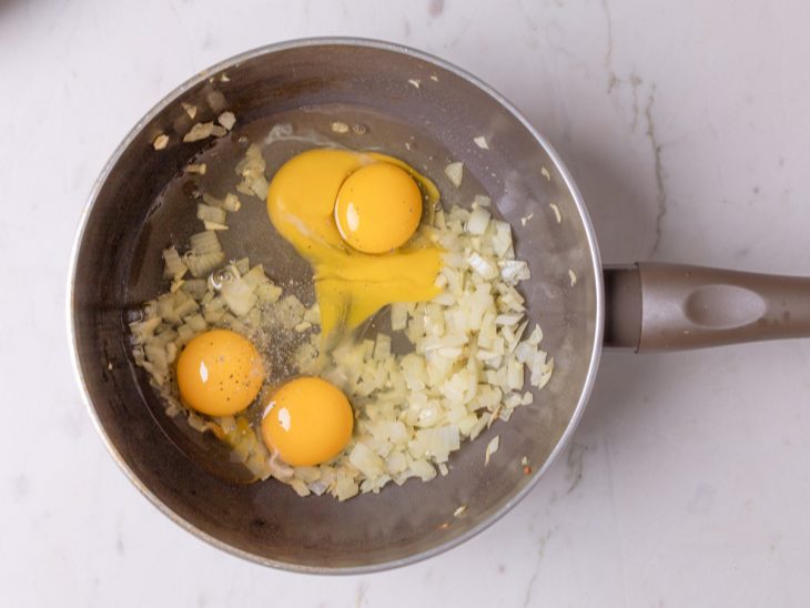 Ovos, sal e pimenta-do-reino adicionados a frigideira.